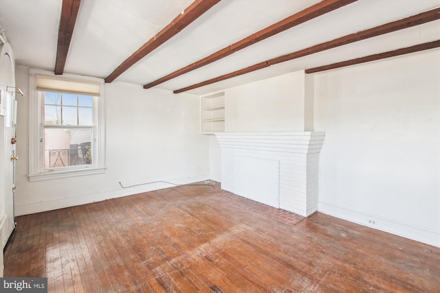 unfurnished living room with hardwood / wood-style flooring, baseboards, and beamed ceiling