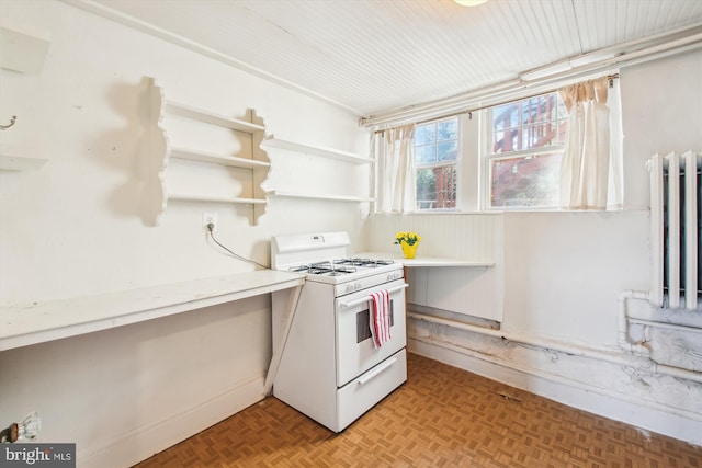 kitchen featuring open shelves, light countertops, and white gas stove