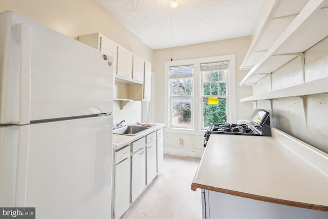 kitchen with open shelves, light countertops, freestanding refrigerator, and white cabinets