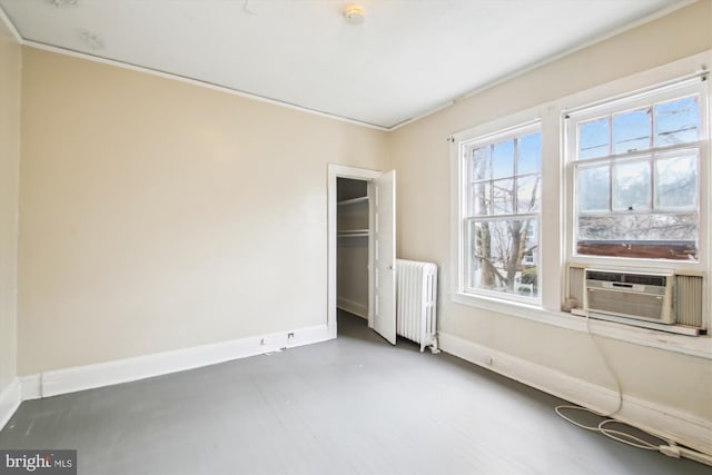 empty room featuring radiator heating unit, baseboards, and cooling unit