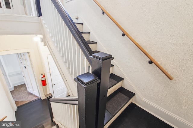 staircase featuring a textured wall