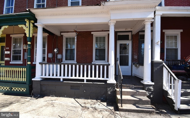 doorway to property with brick siding