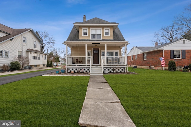 view of front of house with a chimney, a front lawn, a porch, and roof with shingles