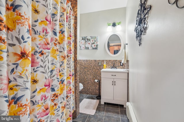 bathroom with vanity, curtained shower, tile patterned flooring, and tile walls