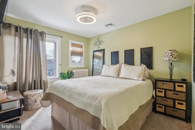 carpeted bedroom featuring visible vents and radiator