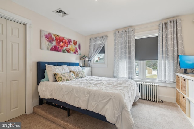 carpeted bedroom featuring radiator heating unit and visible vents