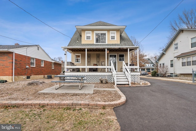 bungalow-style house with covered porch and roof with shingles