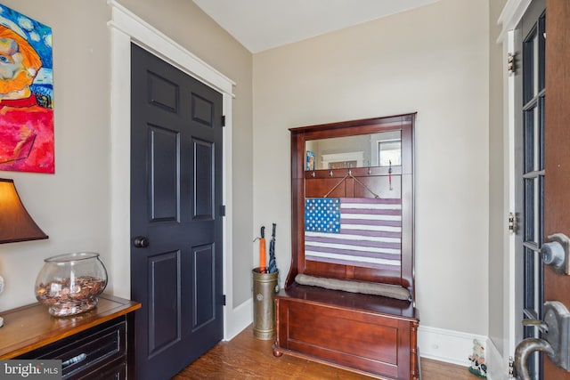 foyer featuring baseboards and dark wood-type flooring