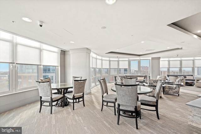 dining space with a raised ceiling and a city view