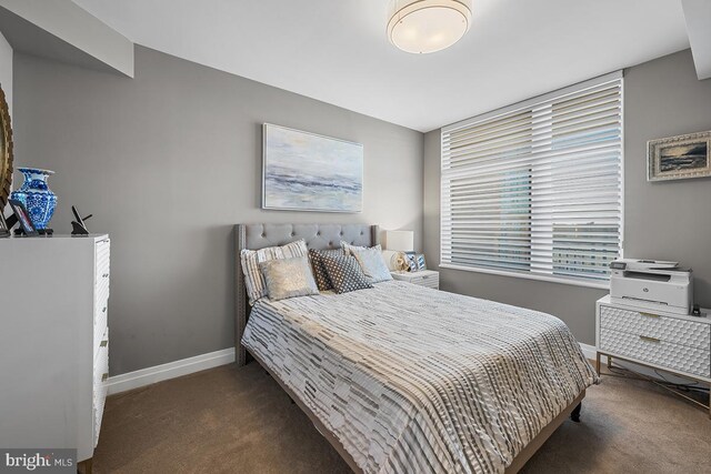 bedroom featuring dark colored carpet and baseboards