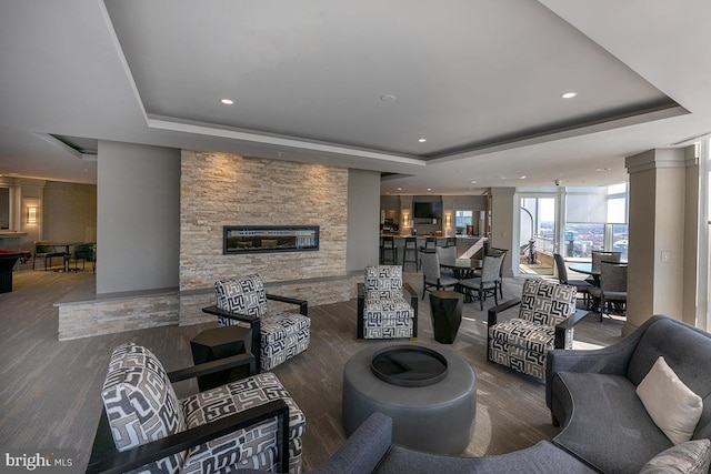 living area with a tray ceiling and recessed lighting