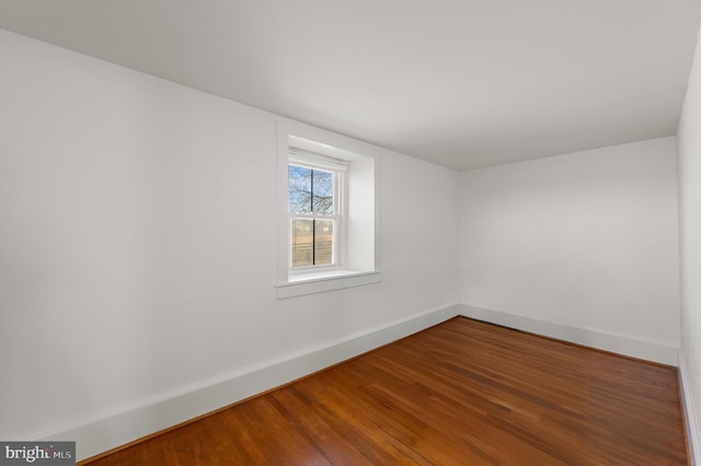 empty room with baseboards and wood finished floors