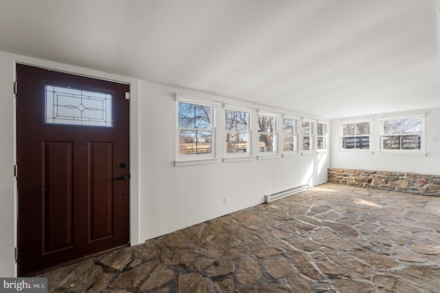 foyer with vaulted ceiling, plenty of natural light, a baseboard radiator, and stone floors