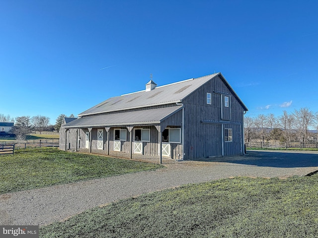 exterior space with a front yard, metal roof, driveway, and fence