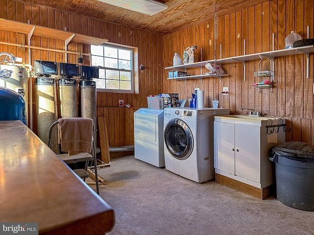 clothes washing area with wooden ceiling, wood walls, cabinet space, and washing machine and clothes dryer