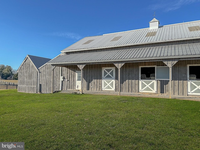 rear view of house with metal roof, a chimney, an outbuilding, and an exterior structure