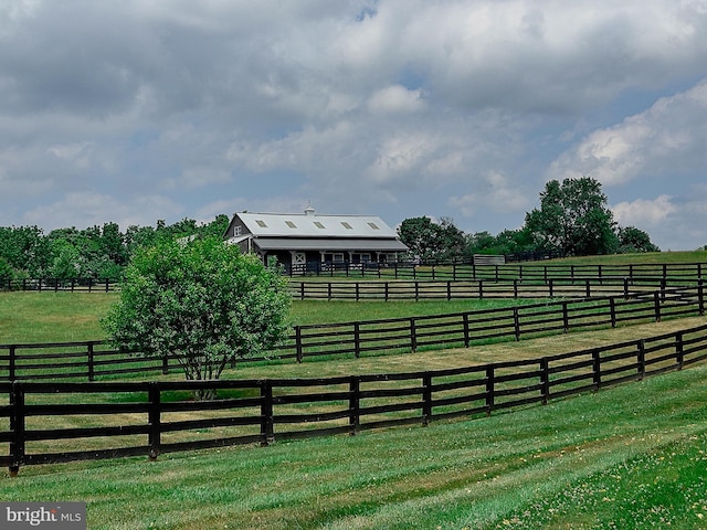 exterior space featuring fence, an enclosed area, and a rural view