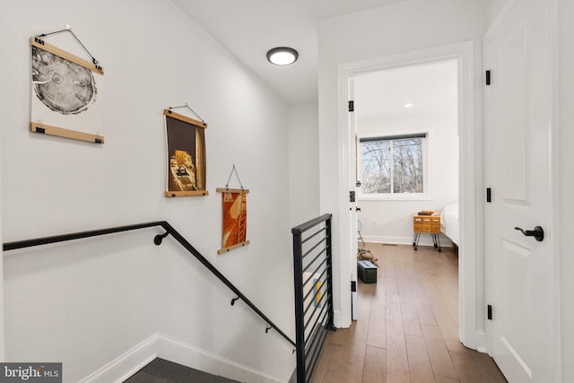 stairway with baseboards and wood finished floors