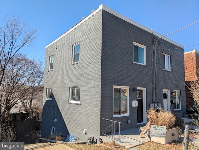 exterior space with fence and brick siding