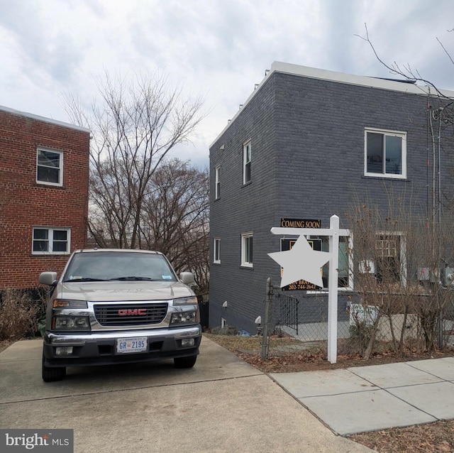 view of home's exterior featuring brick siding and fence