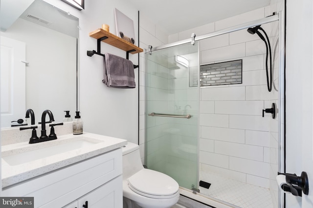 full bath featuring toilet, a stall shower, vanity, and visible vents