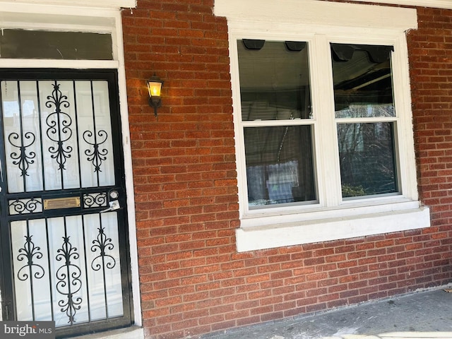 entrance to property featuring brick siding