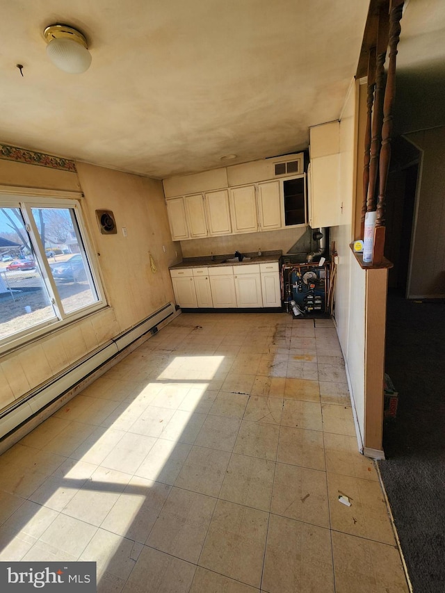 kitchen featuring visible vents, dark countertops, and a baseboard radiator