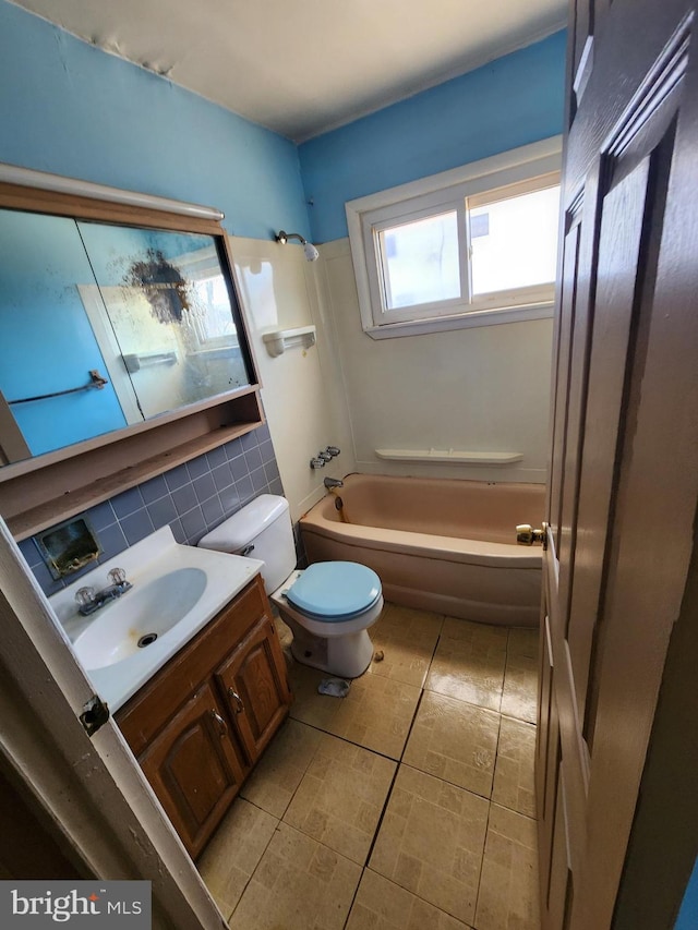 bathroom with toilet,  shower combination, decorative backsplash, and vanity