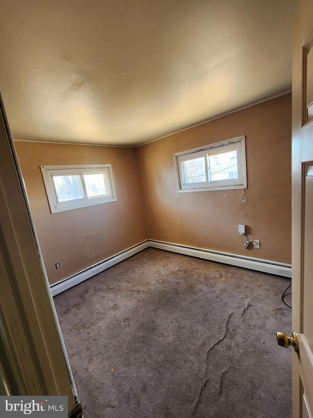 spare room with carpet and a baseboard radiator