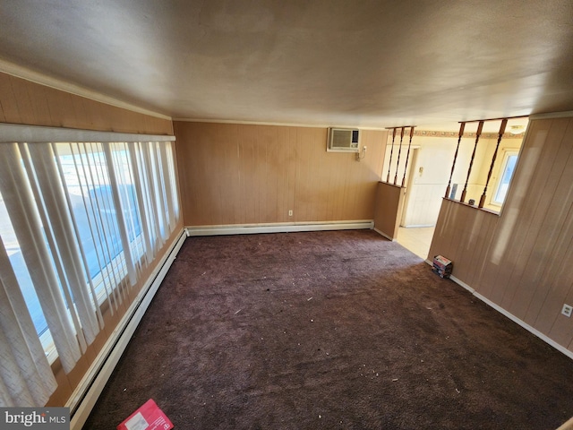 spare room featuring wooden walls, a baseboard radiator, baseboard heating, carpet flooring, and a wall mounted AC