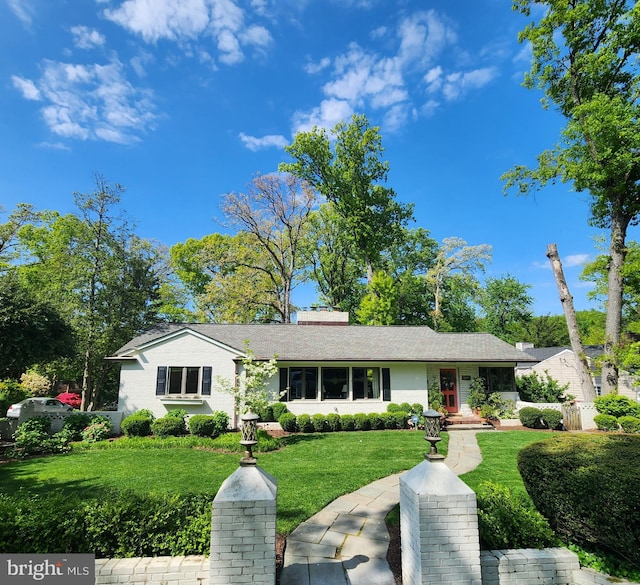 view of front of house with a chimney and a front lawn