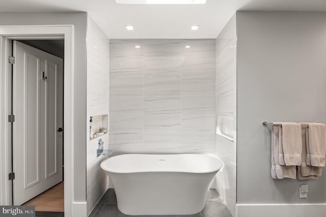 full bath with recessed lighting, tile walls, and a freestanding tub