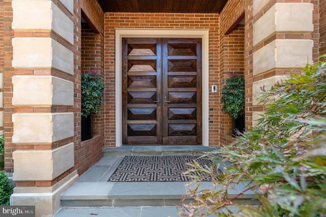 property entrance with brick siding and an attached garage