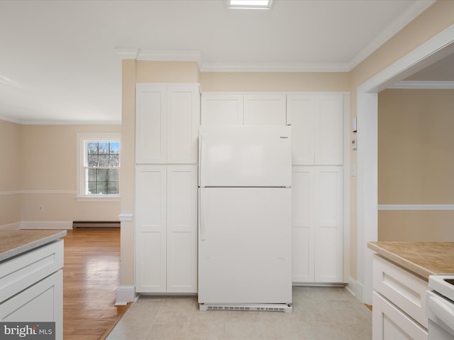 kitchen with crown molding, white cabinets, light countertops, and freestanding refrigerator