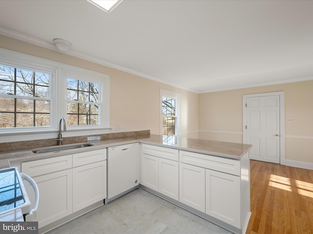 kitchen featuring ornamental molding, white cabinets, a sink, white appliances, and a peninsula