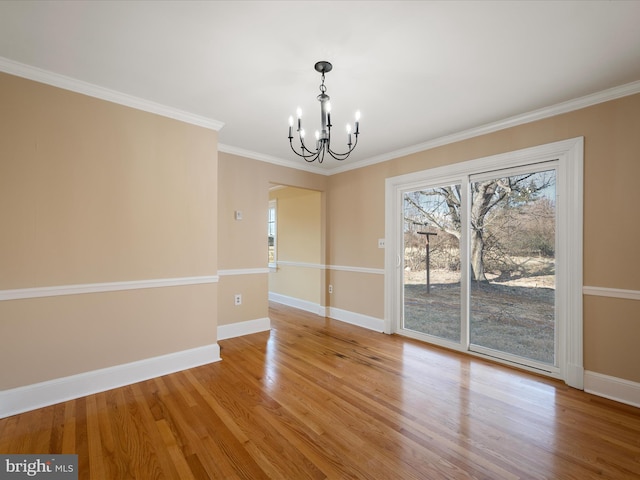 unfurnished dining area with light wood-style flooring, baseboards, a notable chandelier, and ornamental molding