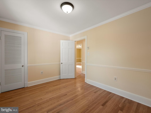 unfurnished bedroom with light wood finished floors, baseboards, a closet, and ornamental molding