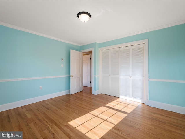 unfurnished bedroom featuring ornamental molding, light wood finished floors, and baseboards