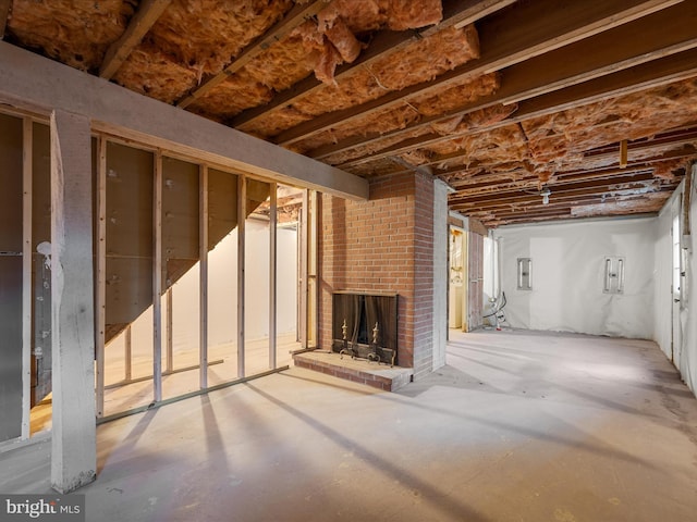 unfinished basement featuring a fireplace and electric panel