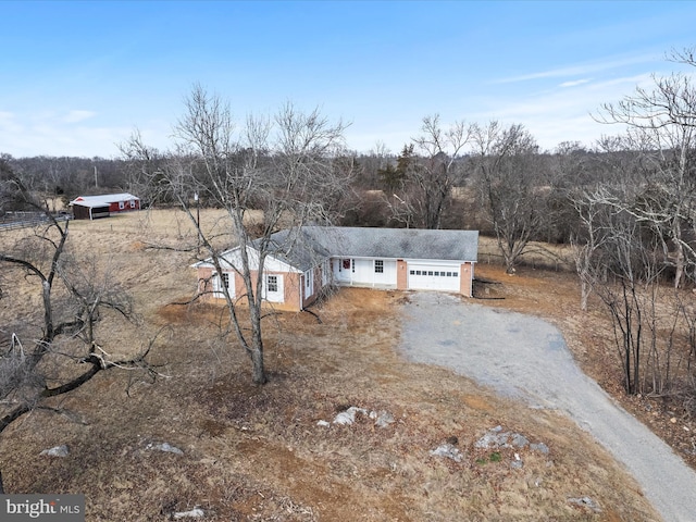 view of front facade featuring a garage and gravel driveway