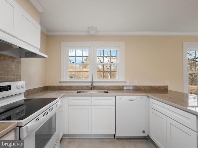 kitchen featuring crown molding, white cabinets, a sink, white appliances, and a peninsula