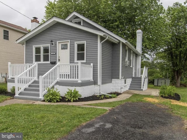 bungalow-style home with a front lawn and a chimney