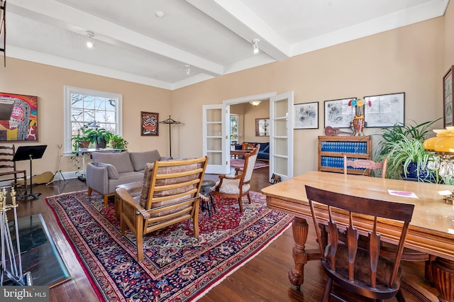 living area with beam ceiling and wood finished floors