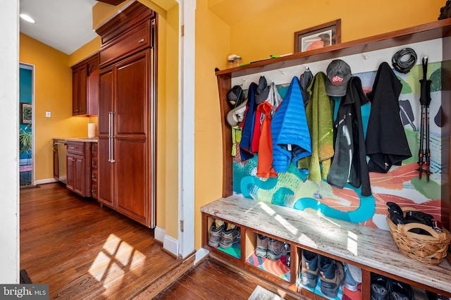 mudroom with lofted ceiling, baseboards, and wood finished floors