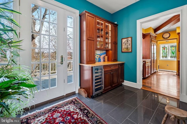 bar featuring beverage cooler, a dry bar, and baseboards