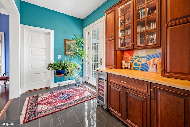 interior space with a bar, beverage cooler, and baseboards