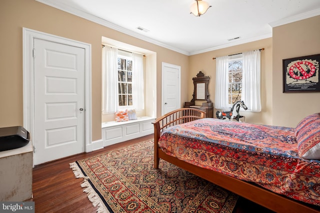 bedroom featuring visible vents, crown molding, and wood finished floors