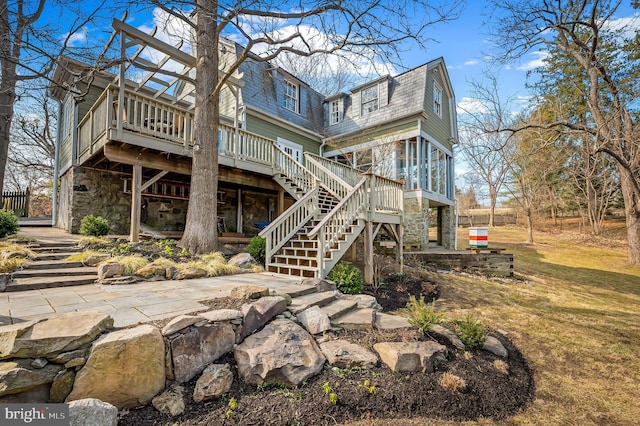 back of house with stone siding, stairway, a patio, and a wooden deck