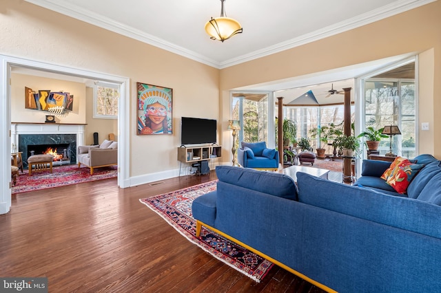 living area featuring ornamental molding, a high end fireplace, baseboards, and wood finished floors