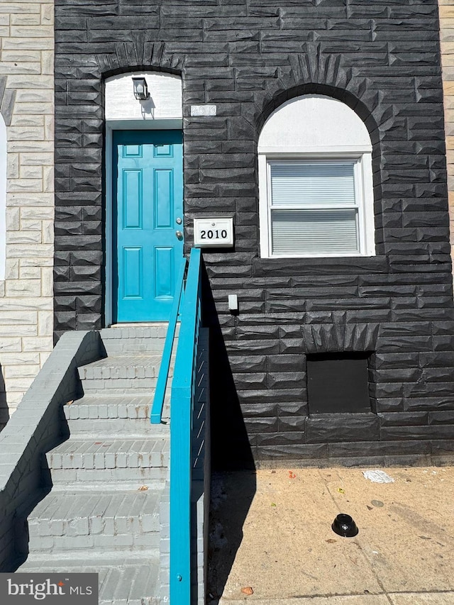 view of exterior entry featuring stone siding